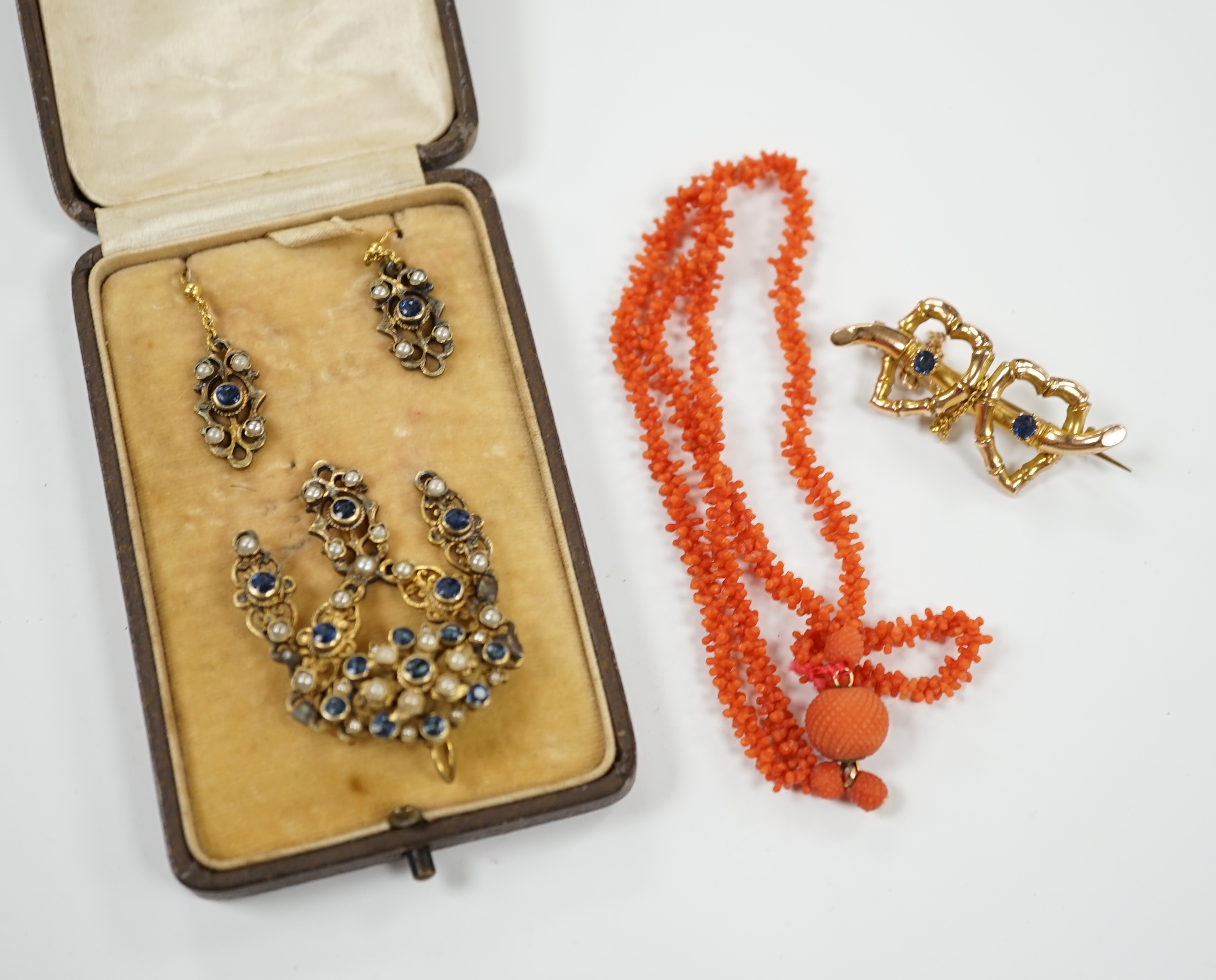 A suite of gilt metal and paste set jewellery, comprising a necklace and pair of earrings, a late Victorian 9ct gold and two stone sapphire set twin hearts brooch and a coral necklace.